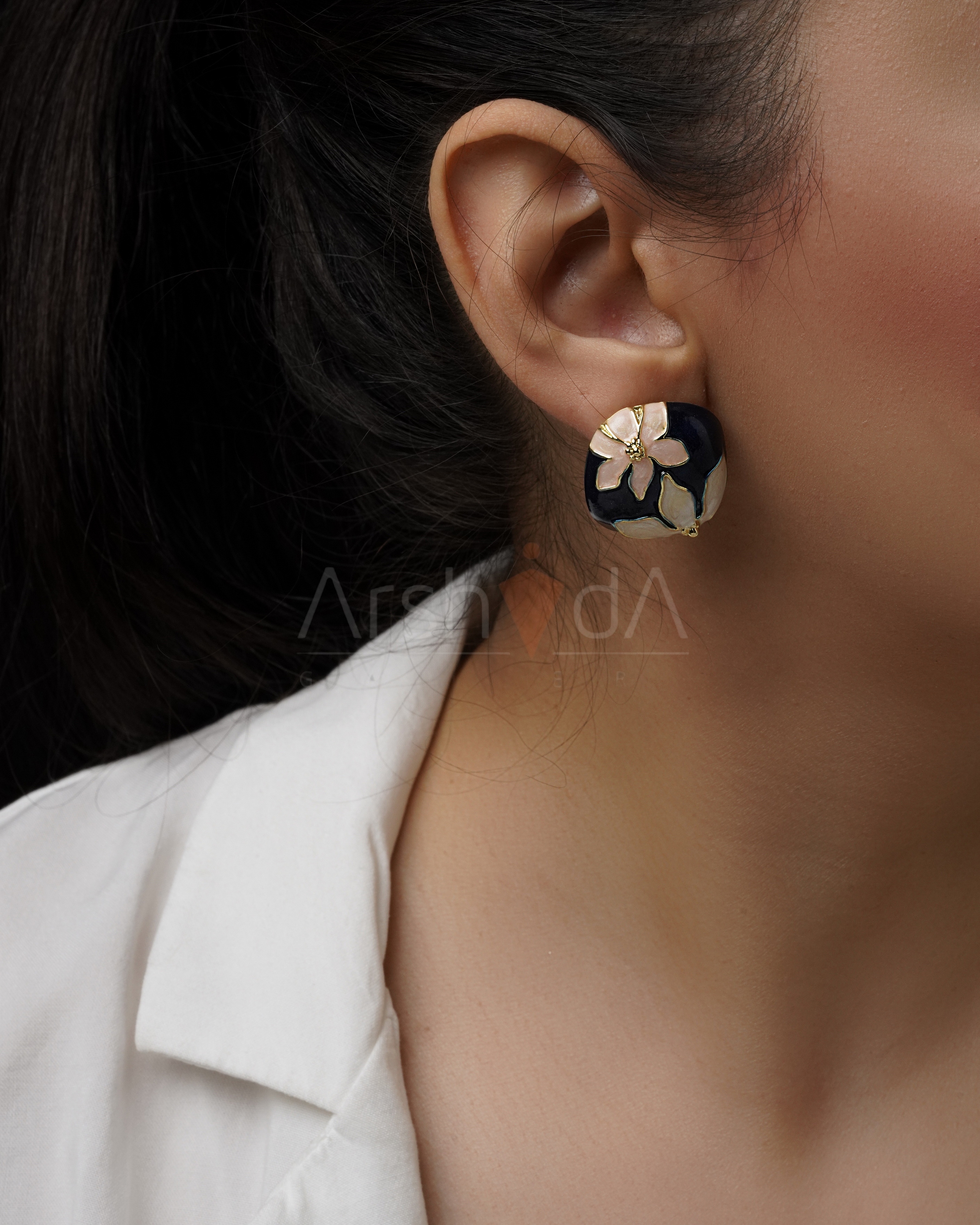 گوشواره زنانه میناکاری طرح گل سفید روی زمینه سرمهای با جزئیات طلایی