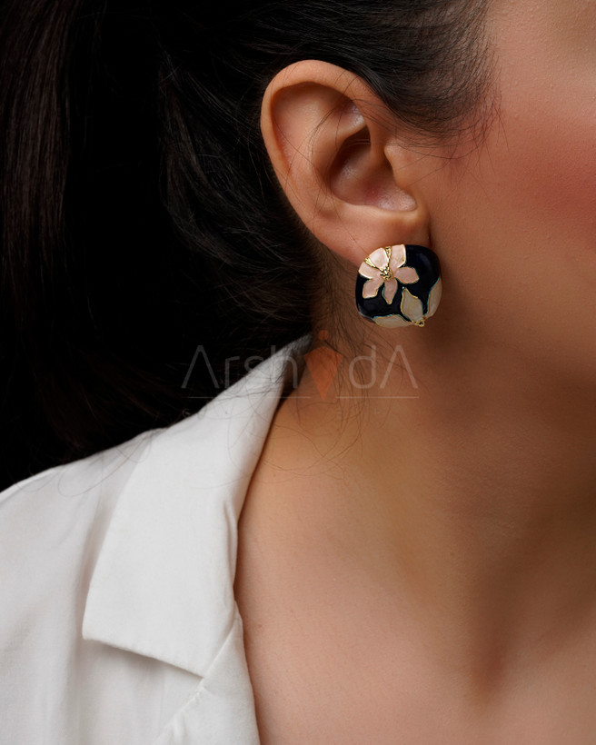 گوشواره زنانه میناکاری طرح گل سفید روی زمینه سرمهای با جزئیات طلایی