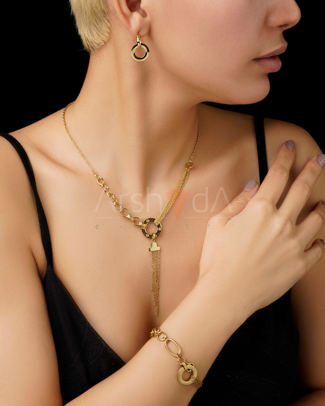 ست زیورآلات طلایی زنانه شامل گردنبند با آویز ریشهای ظریف و دستبند زنجیری و گوشوارههای حلقهای دوتایی