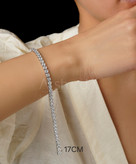 دستبند تنیسی نقرهای مسییکا با نگینهای 4 میلیمتری زیرکونیوم و قفل ایمن کوبایی بر روی مچ دست مدل در آرشیدا گالری.