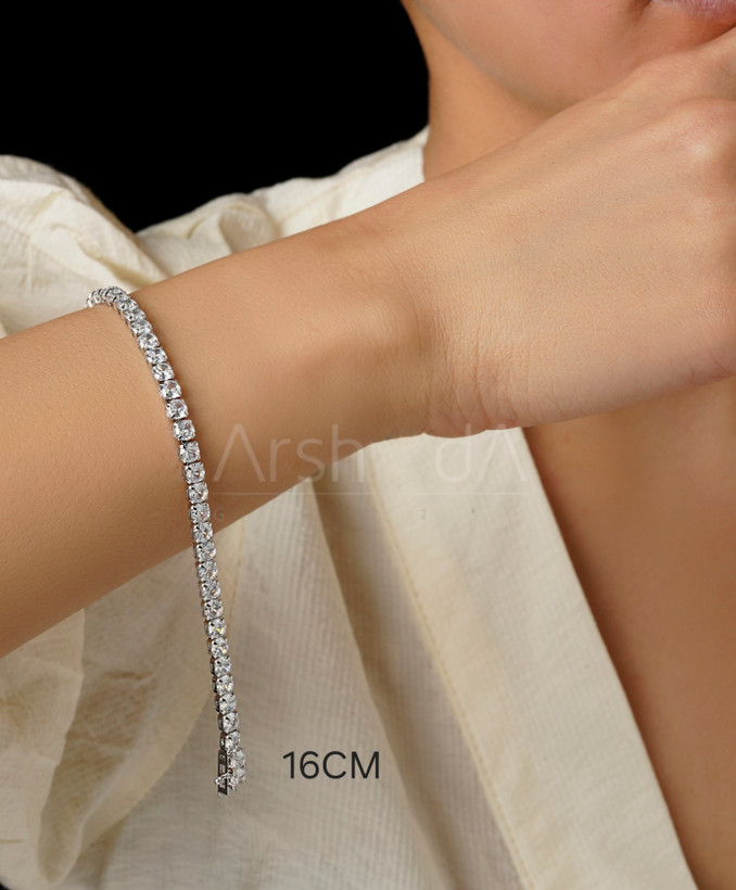 دستبند تنیسی نقرهای مسییکا با نگینهای 4 میلیمتری زیرکونیوم و قفل ایمن کوبایی بر روی مچ دست مدل در آرشیدا گالری.