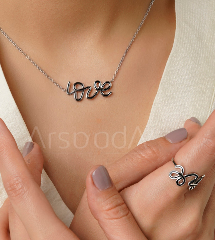 ست گردنبند و انگشتر استیل طرح Love با تزئینات سیاه و سفید مونوکروم و آبکاری رادیوم در آرشیدا گالری.