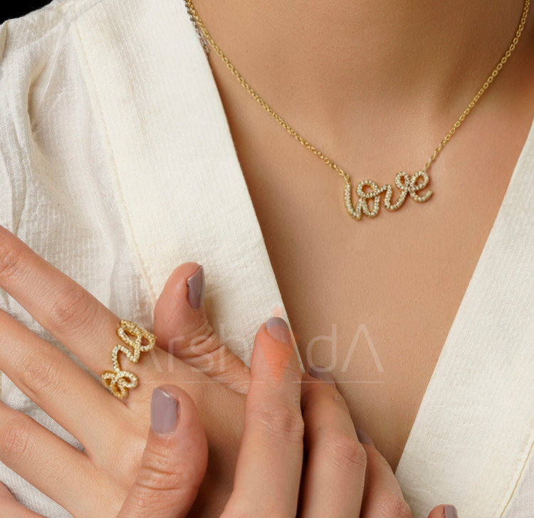 ست گردنبند و انگشتر طلایی و نقرهای طرح نوشته لاو تمام نگین با مخراجکاری درخشان زیرکونیوم و آبکاری طلا روی دست و گردن مدل در آرشیدا گالری.