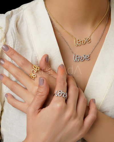 ست گردنبند و انگشتر طلایی و نقرهای طرح نوشته لاو تمام نگین با مخراجکاری درخشان زیرکونیوم و آبکاری طلا روی دست و گردن مدل در آرشیدا گالری.