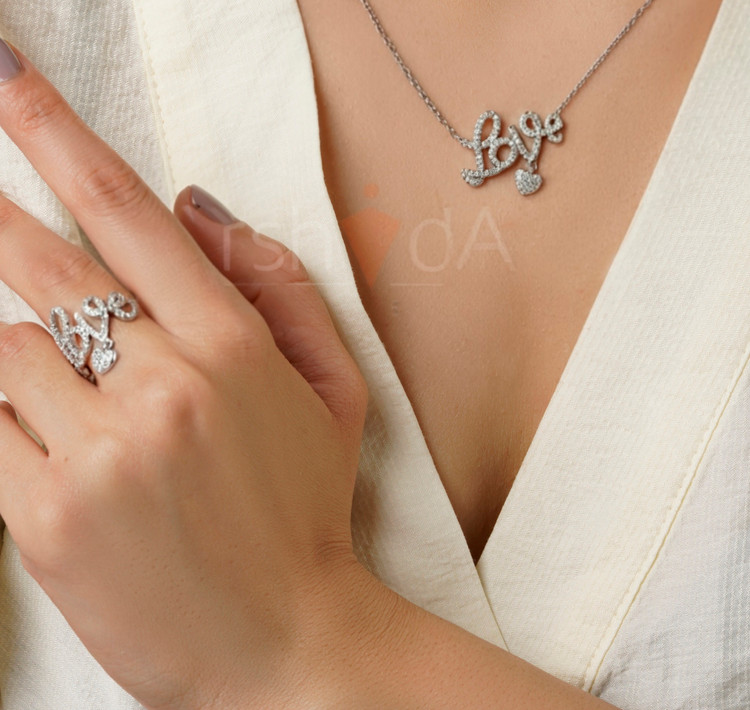 ست گردنبند و انگشتر طلایی و نقرهای طرح لاو با آویز قلبی متحرک الهام گرفته از مدلهای کالیگرافی برند تیفانی در آرشیدا گالری.