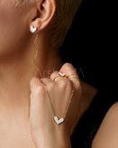 نیم ست استیل طرح قلب با میناکاری رنگی پاستلی و آبکاری طلا ۱۸ عیار بر روی دست و گردن مدل در آرشیدا گالری.