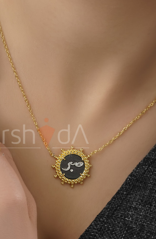 گردنبند زنانه طرح تایپوگرافی صبر با قاب خورشیدی طلایی و زمینه مشکی میناکاری
