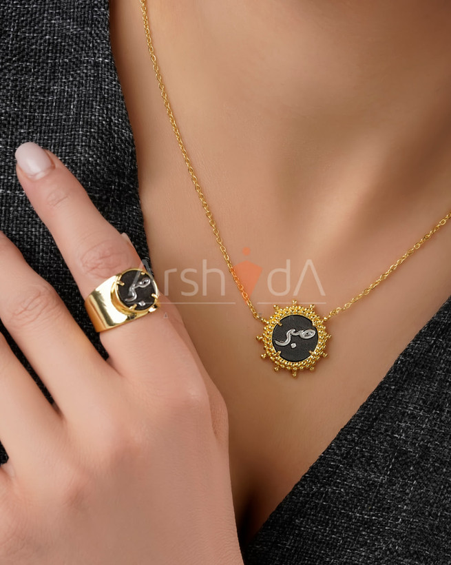 ست گردنبند و انگشتر زنانه طرح تایپوگرافی صبر با قاب خورشیدی طلایی و زمینه مشکی میناکاری
